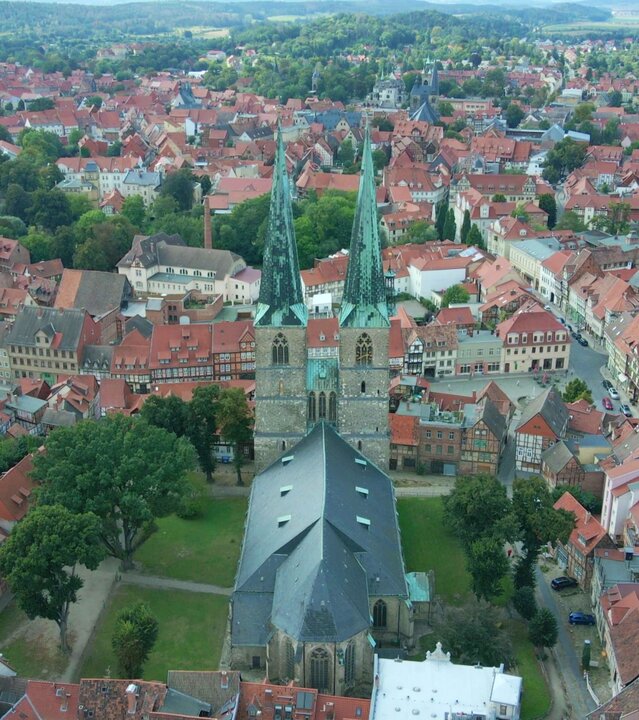 "Evangelischer Gottesdienst - Alles gibt's ein letztes Mal": Luftbild der evangelischen Kirche St. Nikolai mit ihren beiden schlanken, hoch aufragenden Türmen, die inmitten der Altstadt von Quedlinburg steht.