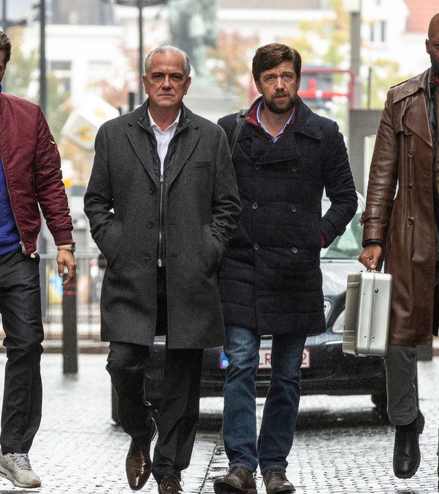 "The Bank Hacker": Alidor Van Praet (Gene Bervoets) läuft mit Prince (Manuel Broekman), Bart (Koen De Graeve), und Souleymane (Claude Musungayi) auf der Straße. Hinter ihnen fährt ein schwarzes Auto.