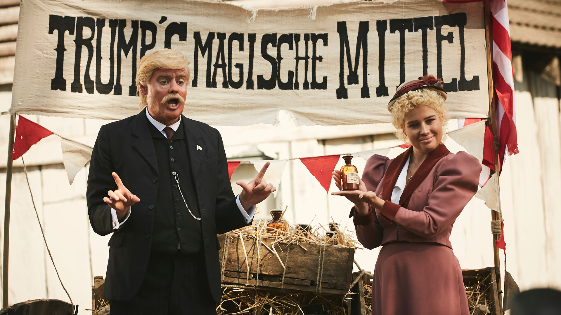 "Sketch History – Neues von gestern": Ein Vorfahre Trumps (Max Giermann) steht im Wilden Westen auf einem Heuwagen, neben ihm preist eine blonde Frau ein Fläschchen an. Über den beiden prangt ein Band mit der Aufschrift "Trump''s Magische Mittel".