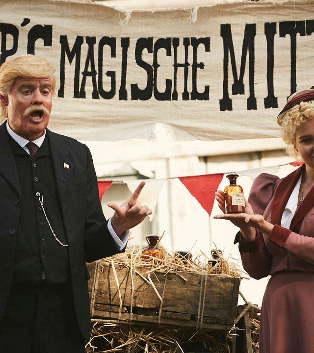 "Sketch History – Neues von gestern": Ein Vorfahre Trumps (Max Giermann) steht im Wilden Westen auf einem Heuwagen, neben ihm preist eine blonde Frau ein Fläschchen an. Über den beiden prangt ein Band mit der Aufschrift "Trump''s Magische Mittel".