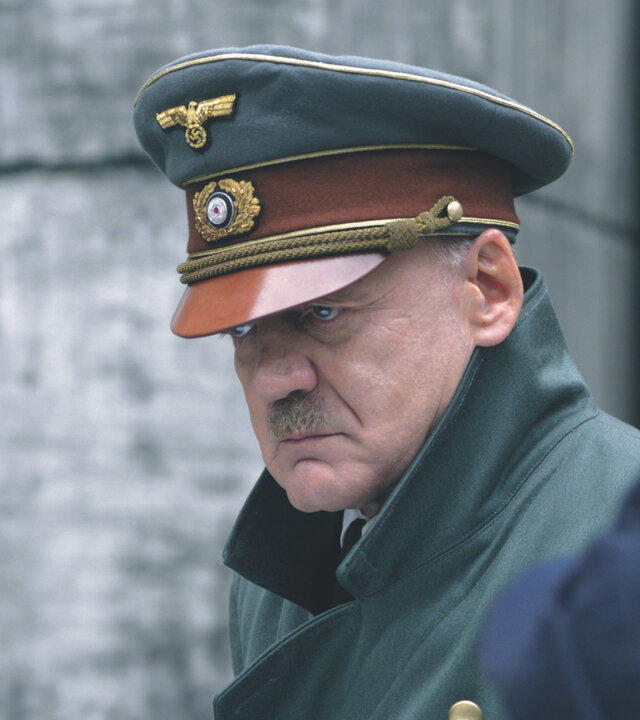 "Der Untergang": Adolf Hitler (Bruno Ganz) steht uniformiert und ernst schauend vor einem Bunker. Im Hintergrund ist ein Soldat zu sehen.