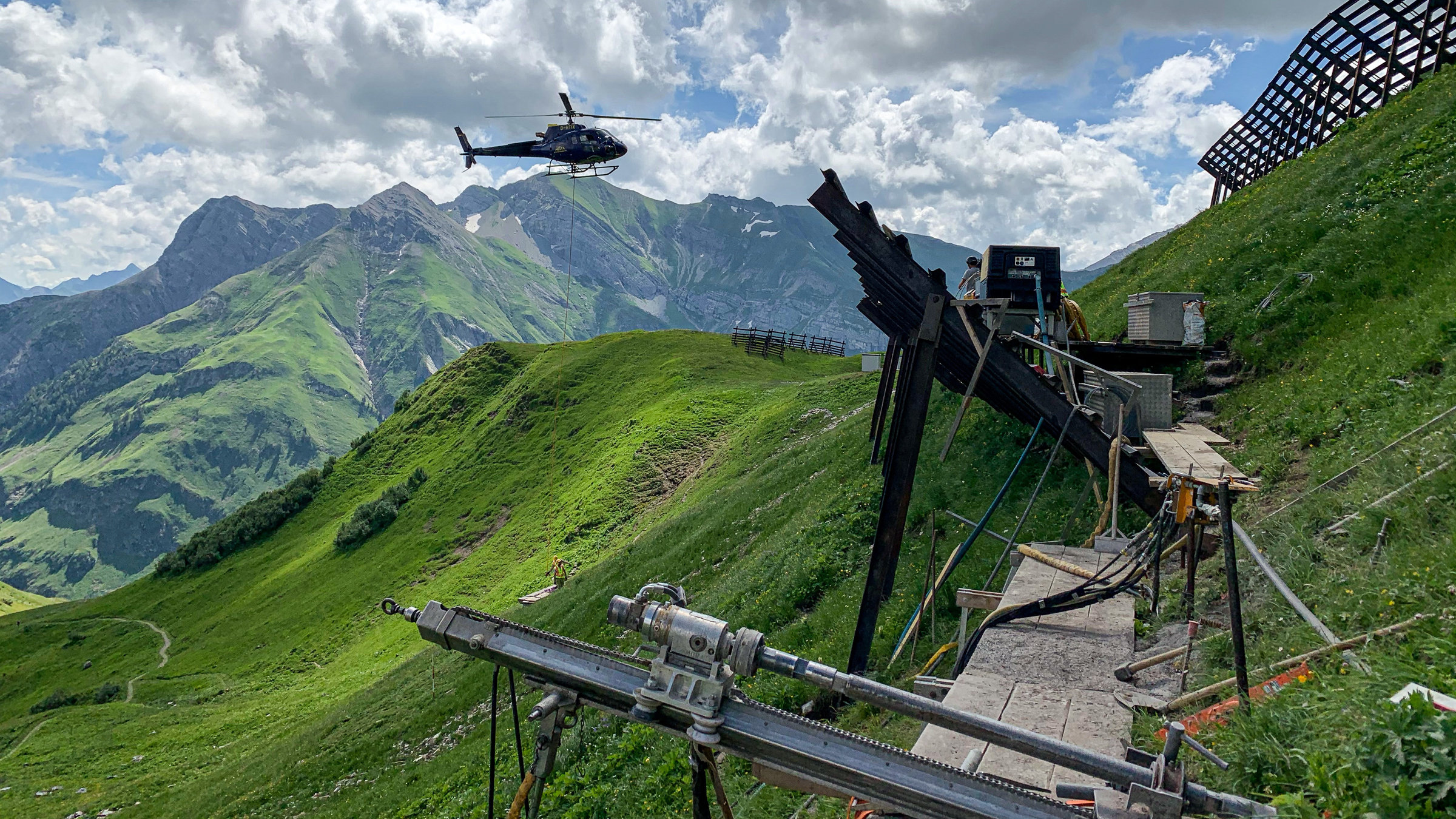 "Vom Leben und Arbeiten im Hochgebirge": Lawinenverbauung, Hubschauber im Hintergrund vor Bergpanorama