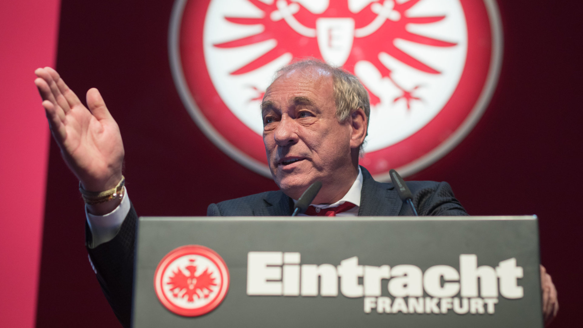 "Eröffnungsfeier zur Woche der Brüderlichkeit": Peter Fischer mit nach vorne rechts deutender Geste steht hinter einem Rednerpult und spricht nach rechts.