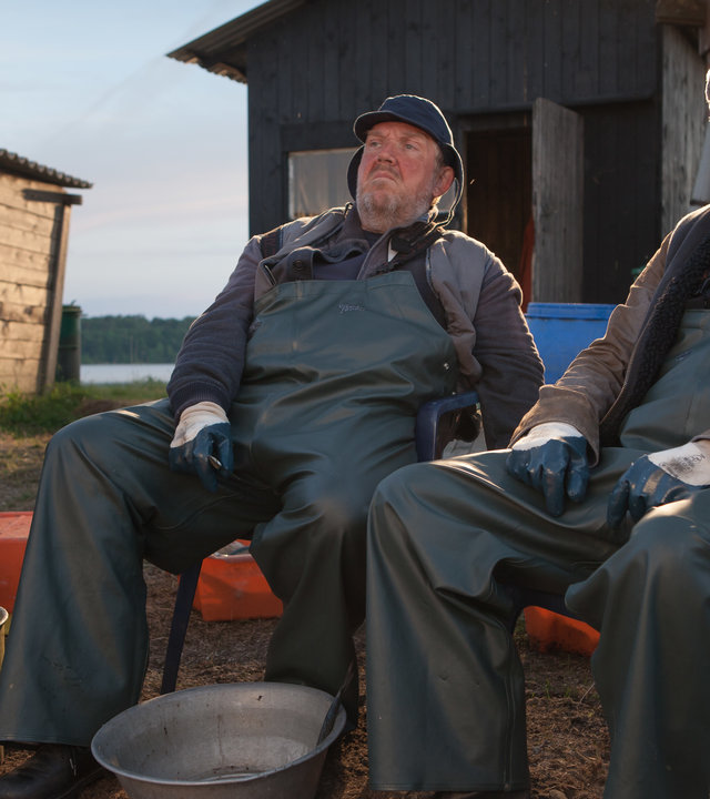 "Große Fische, kleine Fische": Paul (Uwe Ochsenknecht) und Fiete (Dietmar Bär) sitzen zusammen in Fischerkleidung auf einer Bank. Vor ihnen leere Eimer.