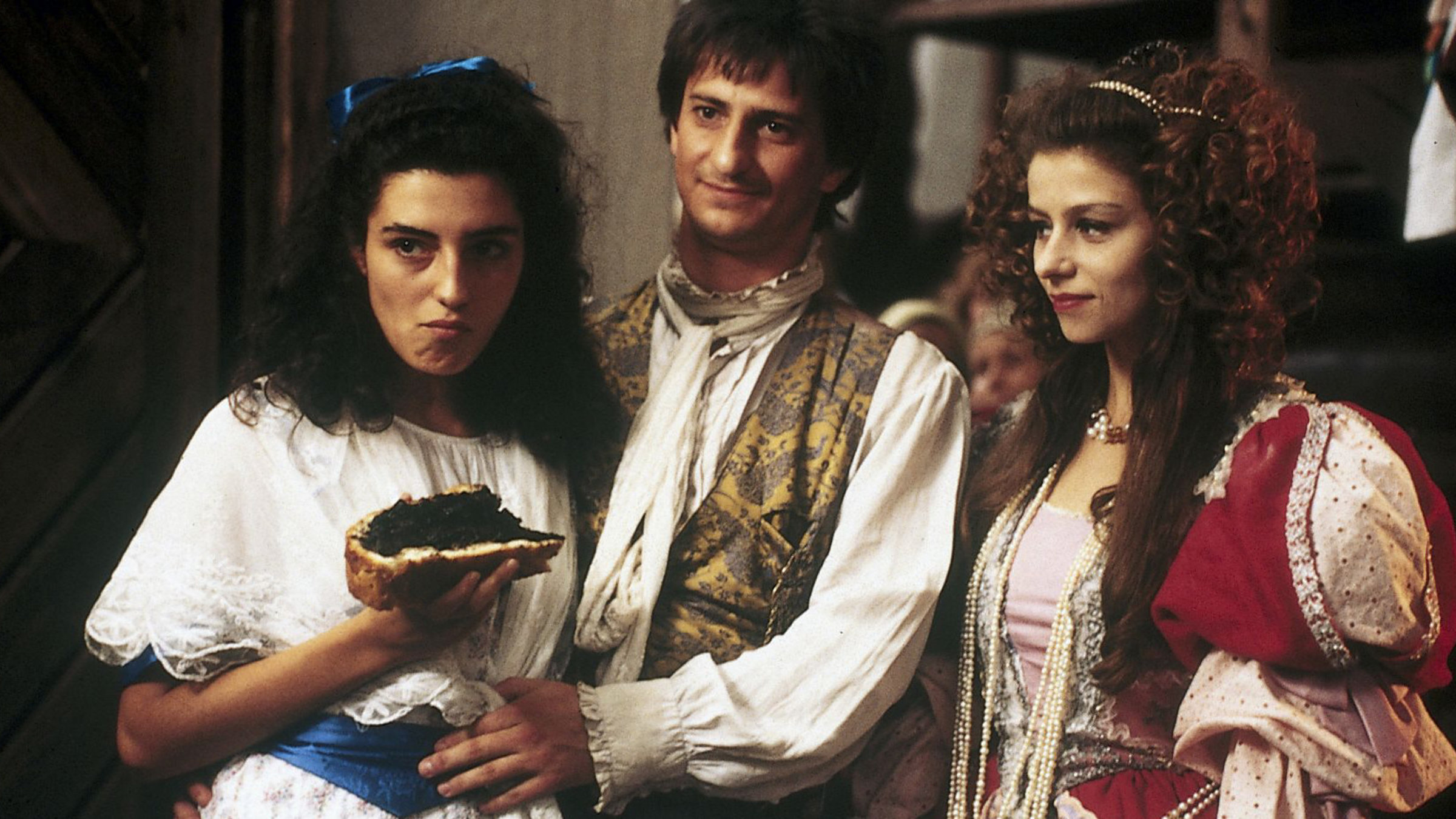 "Das tapfere Schneiderlein": Die Prinzessin (Amanda Sandrelli), das tapfere Schneiderlein (Miroslav Noga) und Franziska (Monica Molina) stehen nebeneinander und schauen sich etwas an. Die Prinzessin hat ein Brot in der Hand.