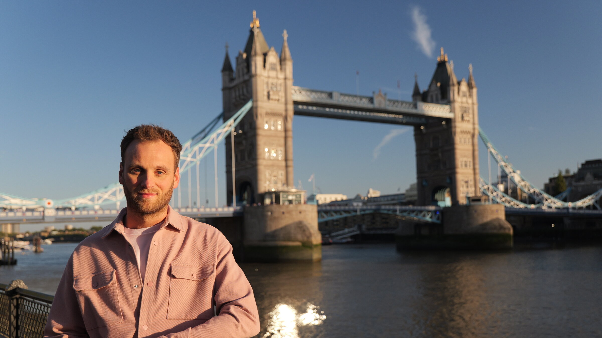 "Terra X: Weltstädte - London": Leon Windscheid steht am Ufer der Themse, hinter ihm führt die Tower Bridge über den Fluss.