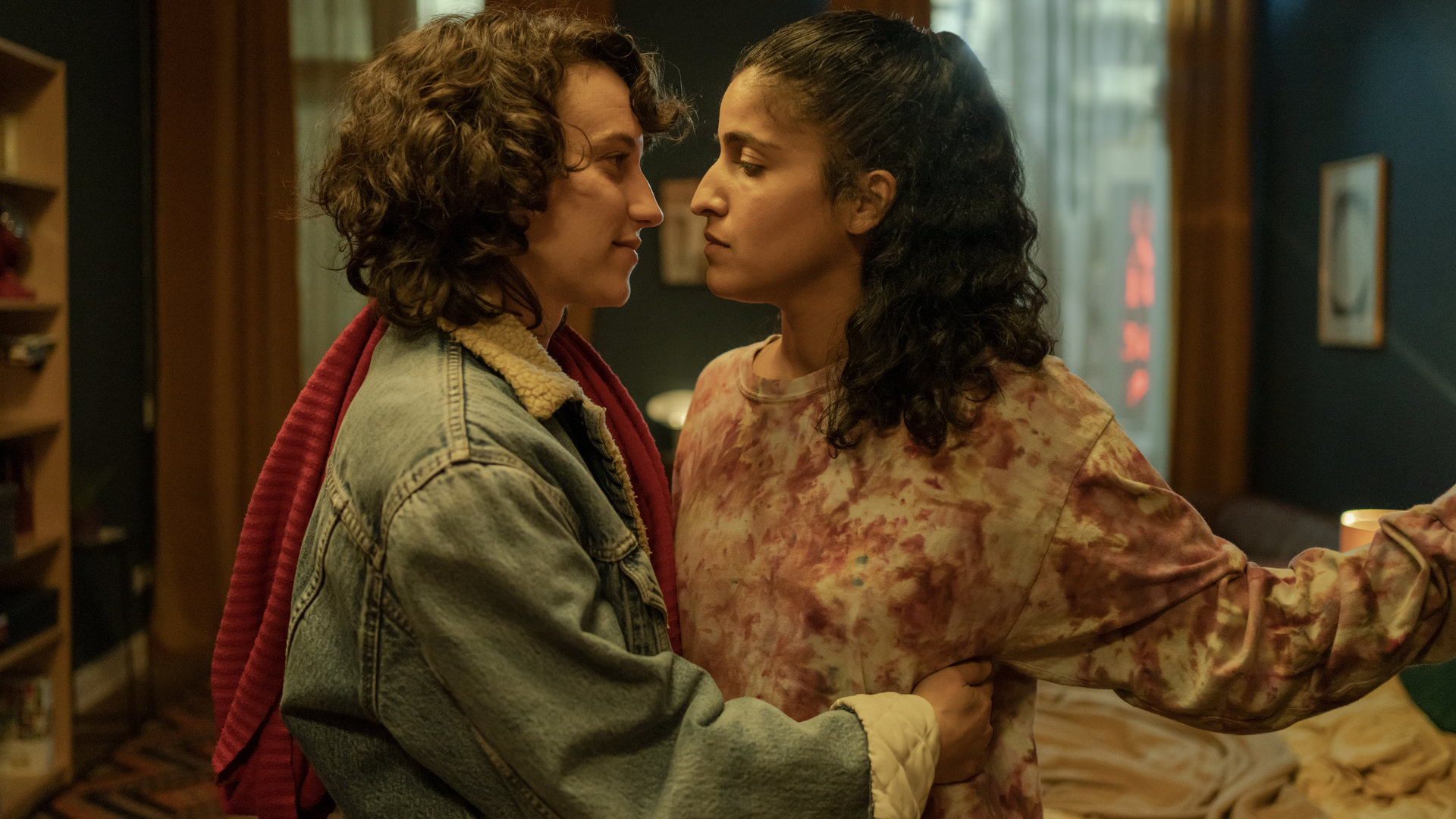 "Loving Her - Loving Hope": Isabel  (Annick Durán Kandzior) und Hanna (Banafshe Hourmazdi) stehen in einem Wohnraum eng beieinander. Isabel umarmt Hanna. Beide sehen sich tief in die Augen.