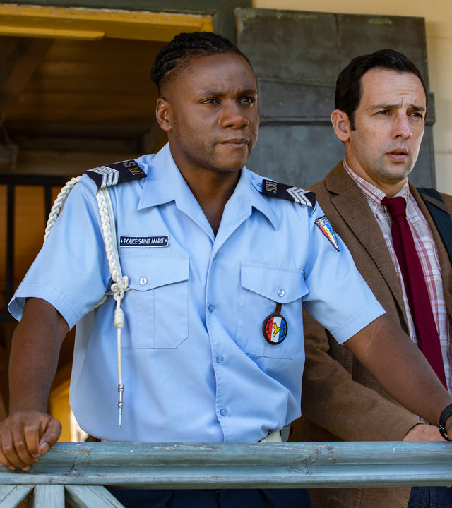 "Death in Paradise - Vergessen": DS Cassell (Joséphine Jobert), Sergeant Hooper (Tobi Bakare) und DI Parker (Ralf Little) stehen vor dem Polizeirevier und schauen nachdenklich in die Ferne.