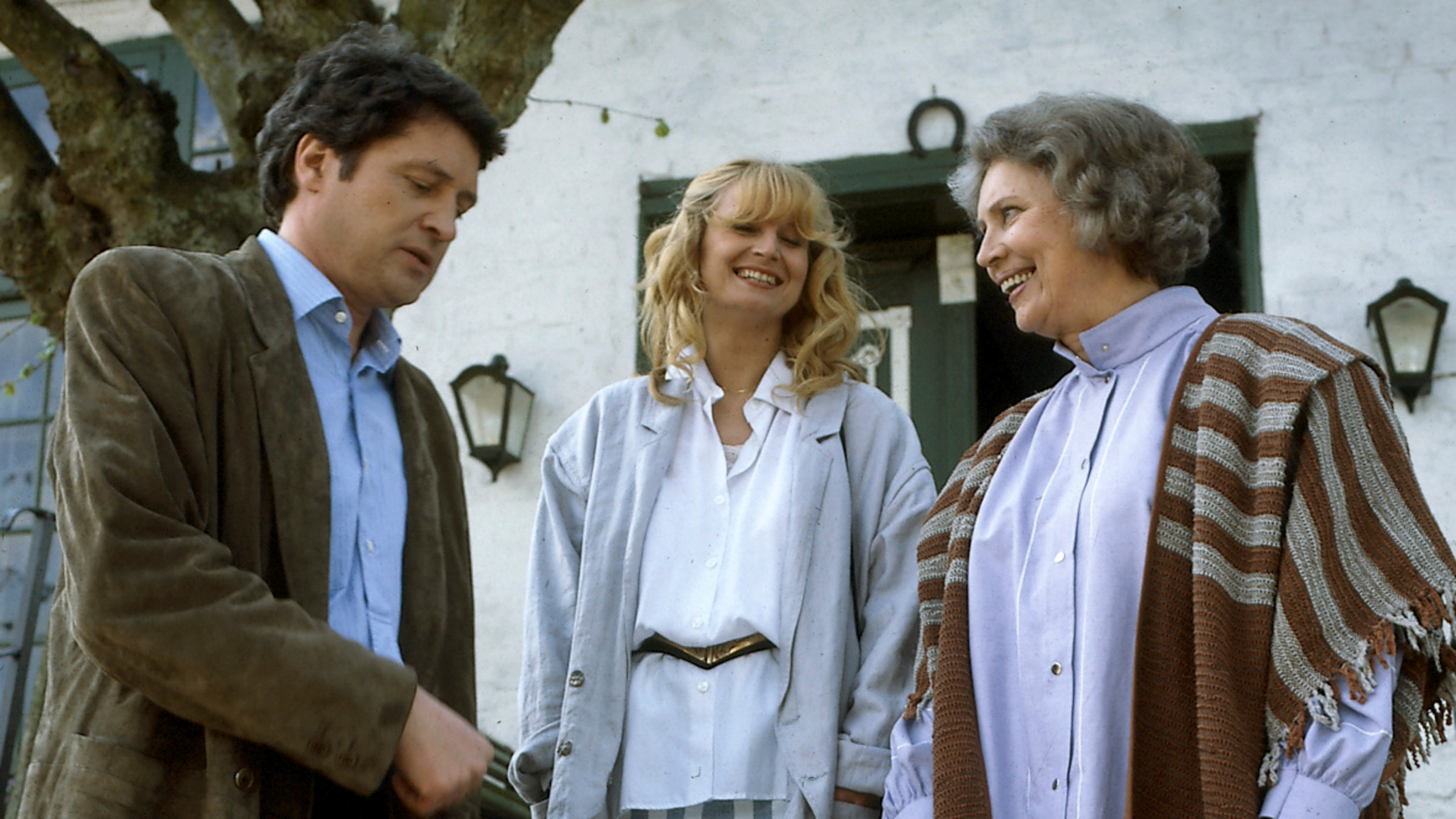 "Der Landarzt - Große Kinder - große Sorgen": Olga (Antje Weisgerber) steht mit ihrem Sohn Karsten (Christian Quadflieg) und dessen neuer Liebe Sabine (Regine Lamster) vor einem Haus. Die beiden Frauen lachen.