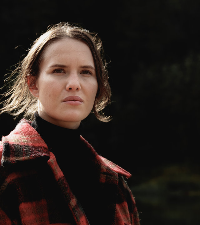 "Cryptid - Das Opfer von Lisa": Lisa (Astrid Morberg) steht mit ihrer Jacke draußen und schaut in Gedanken in die Ferne.