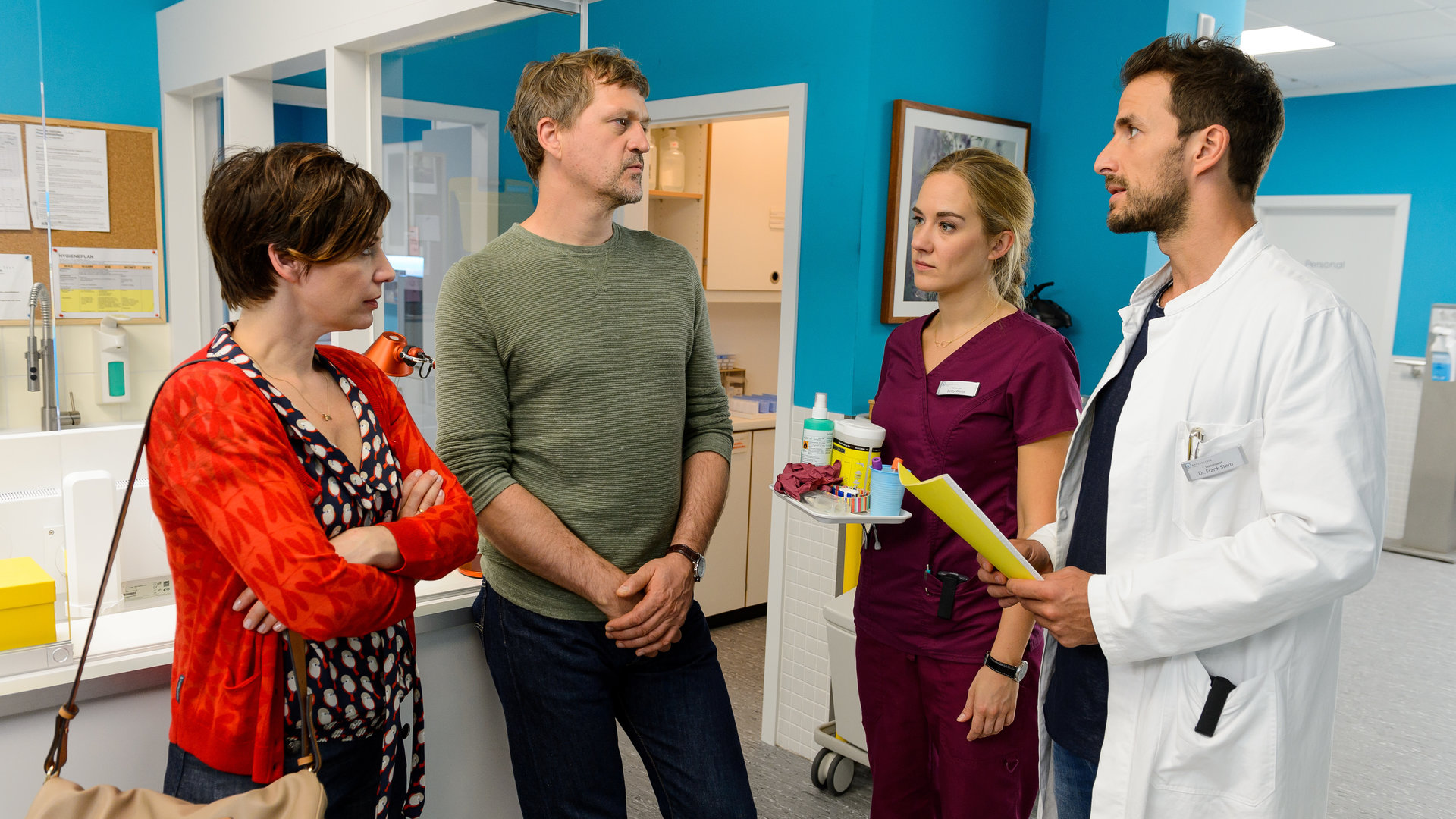 "Bettys Diagnose - Aufbruch": Kerstin Hellberg (Caro Scrimali) und ihr Mann Roland Hellberg (Patrick von Blume) stehen mit Betty Weiss (Annina Hellenthal) und Dr. Frank Stern (Max Alberti) auf dem Krankenhausflur und unterhalten sich.