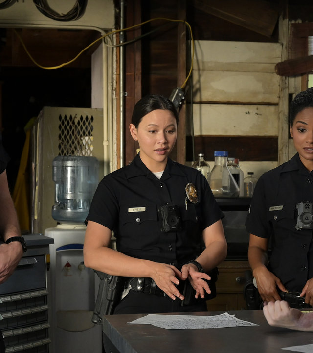 "The Rookie - Am Strand": Chen (Melissa O'Neil), Nolan (Nathan Fillion) und Harper (Mekia Cox) stehen in einer Garage und schauen auf einen abgetrennten Arm, der vor ihnen auf einem Tisch liegt.