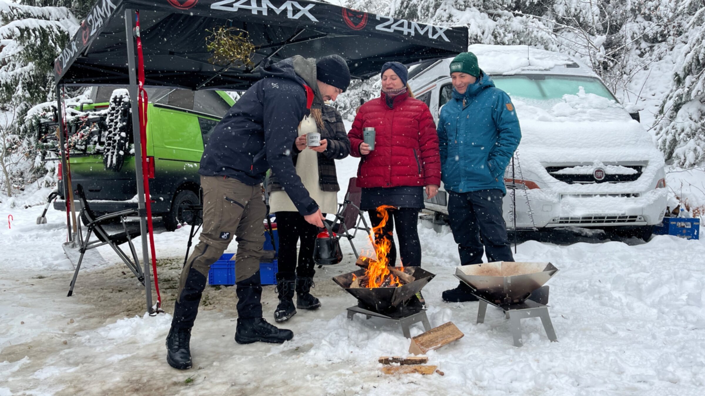 "ZDF.reportage: Cooles Camping - Winter im Wohnmobil": Camper mit Glühwein in der Hand stehen im Freien vor einer Feuerschale und unterhalten sich.