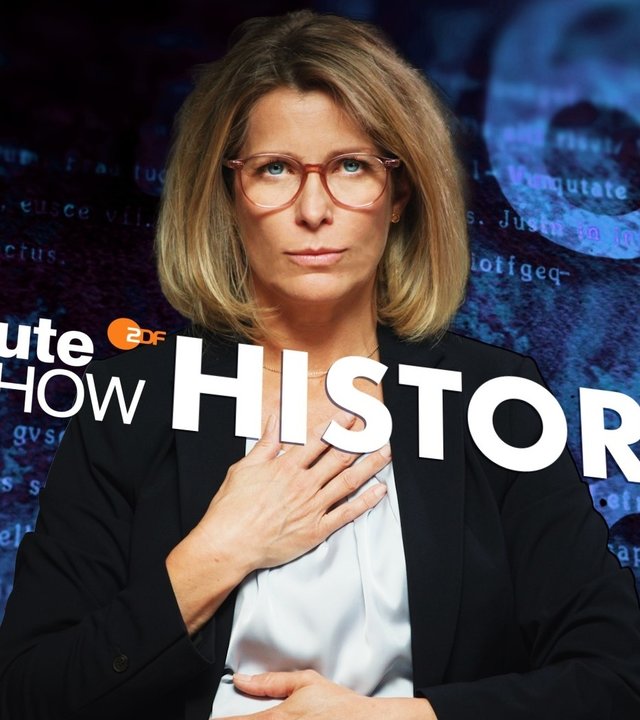 "heute-show history - Oh Mann,... 60 Jahre Frauen im ZDF": Montage: Valerie Niehaus trägt einen schwarzen Blazer und blickt in die Kamera. Sie hält die eine Hand vor ihren Ausschnitt, die andere vor ihren Bauch. Vor ihr liegt das Logo der "heute-show", in der oberen Bildecke ist die Zahl 63.