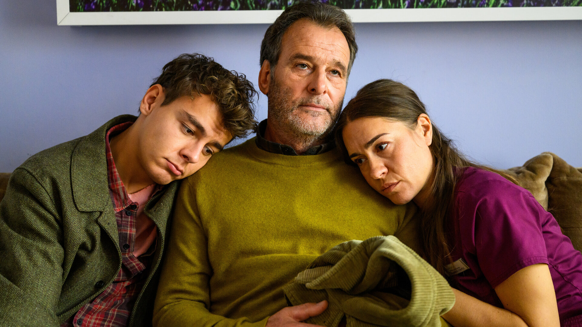 "Bettys Diagnose - Liebe auf BewÃ¤hrung": Simon (Ivan BariÅ¡iÄ) und Betty (Henrike Hahn) sitzen neben ihrem Vater Martin (Joachim Raaf) auf dem Sofa und lehnen sich an seine Schulter. Martin hÃ¤lt eine Jacke in seinen HÃ¤nden.