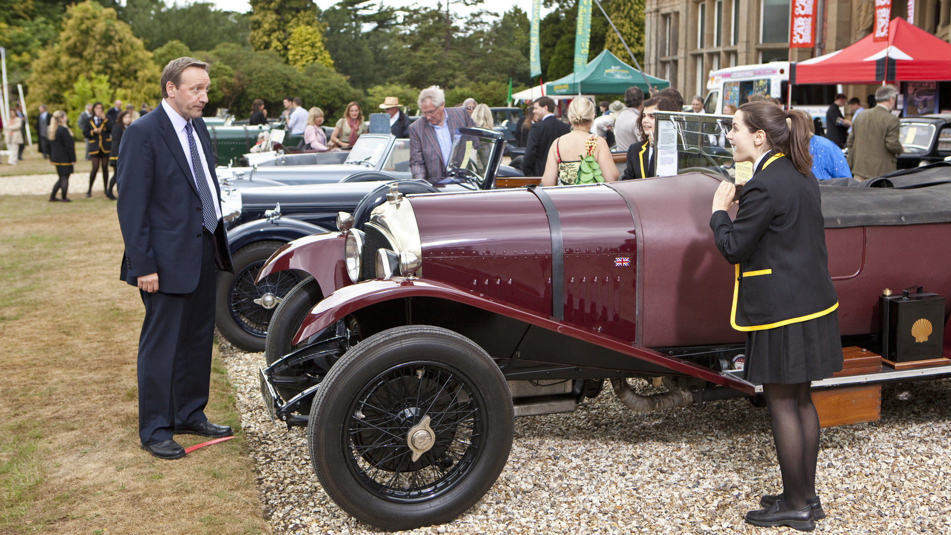 "Inspector Barnaby - Unter Oldtimern": DCI John Barnaby (Neil Dudgeon) und Nerys (Daisy Keeping) begutachten einen Oldtimer bei einer Ausstellung.
