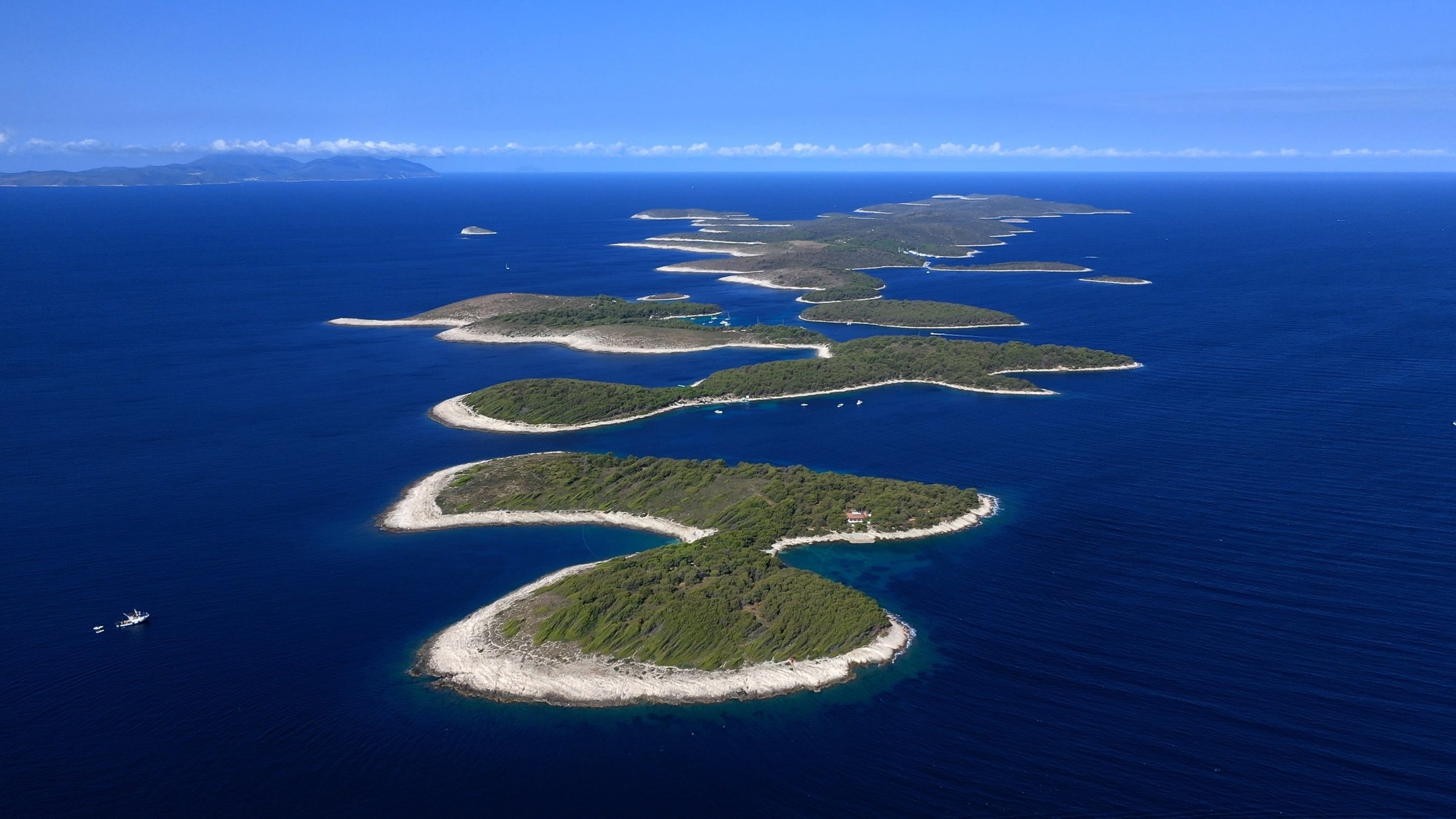 "Kroatien - Land der tausend Inseln": Luftaufnahme einer Gruppe von Inseln mit grüner Vegetation und breiten Sandstränden in tiefblauem Meer