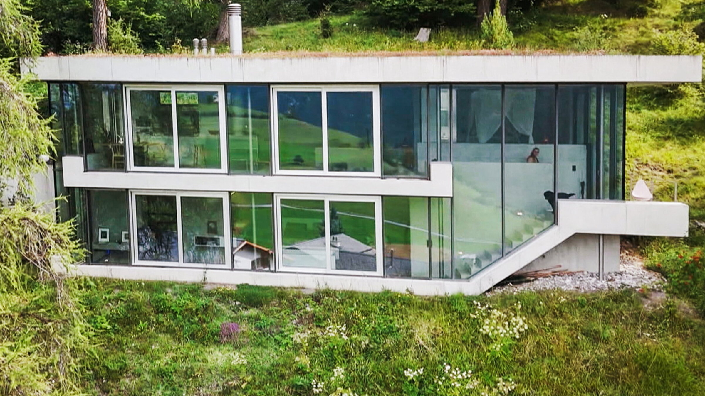 "Offene TÃ¼ren â Architekturgeschichten aus GraubÃ¼nden": Das Glas-Chalet "Tgaplottas" im Wald eingebettet â Architekt Christoph Cavigelli.