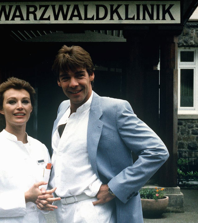 "Die Schwarzwaldklinik - Das Findelkind": Udo (Sascha Hehn) und Katharina (Ilona Grübel) stehen lächelnd am Eingang der Schwarzwaldklinik.