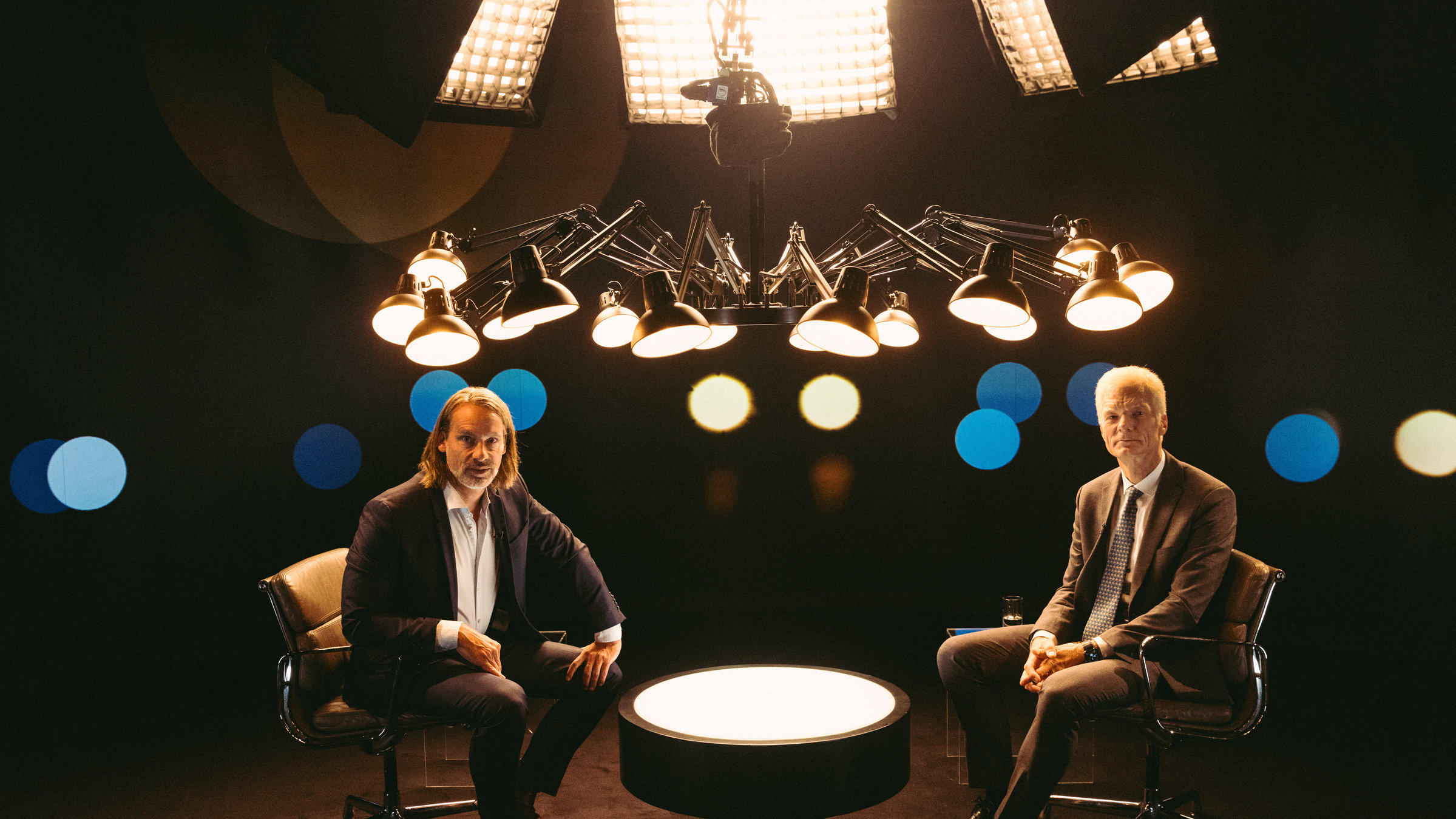 "Precht - Bessere Schulen - Wie gelingt gute Bildung für alle?": Richard David Precht und Andreas Schleicher in einer Studiototalen. Sie sitzen sich über einen Tischen hinweg gegenüber und blicken beide in die Kamera.