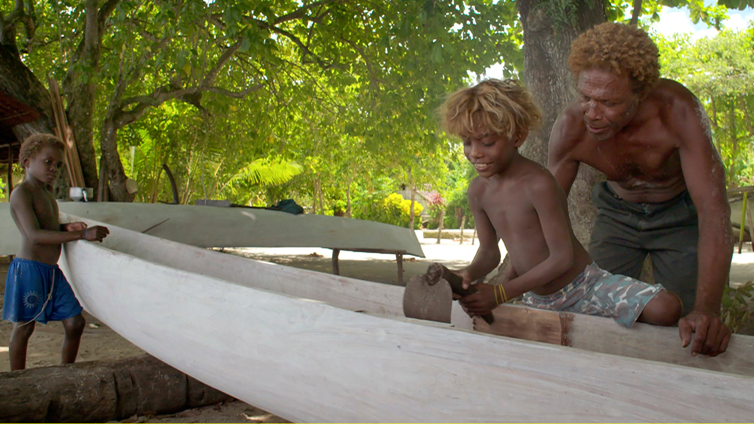 "Der Bismarck-Archipel": Ein Mann und zwei Kinder beim Bootsbau