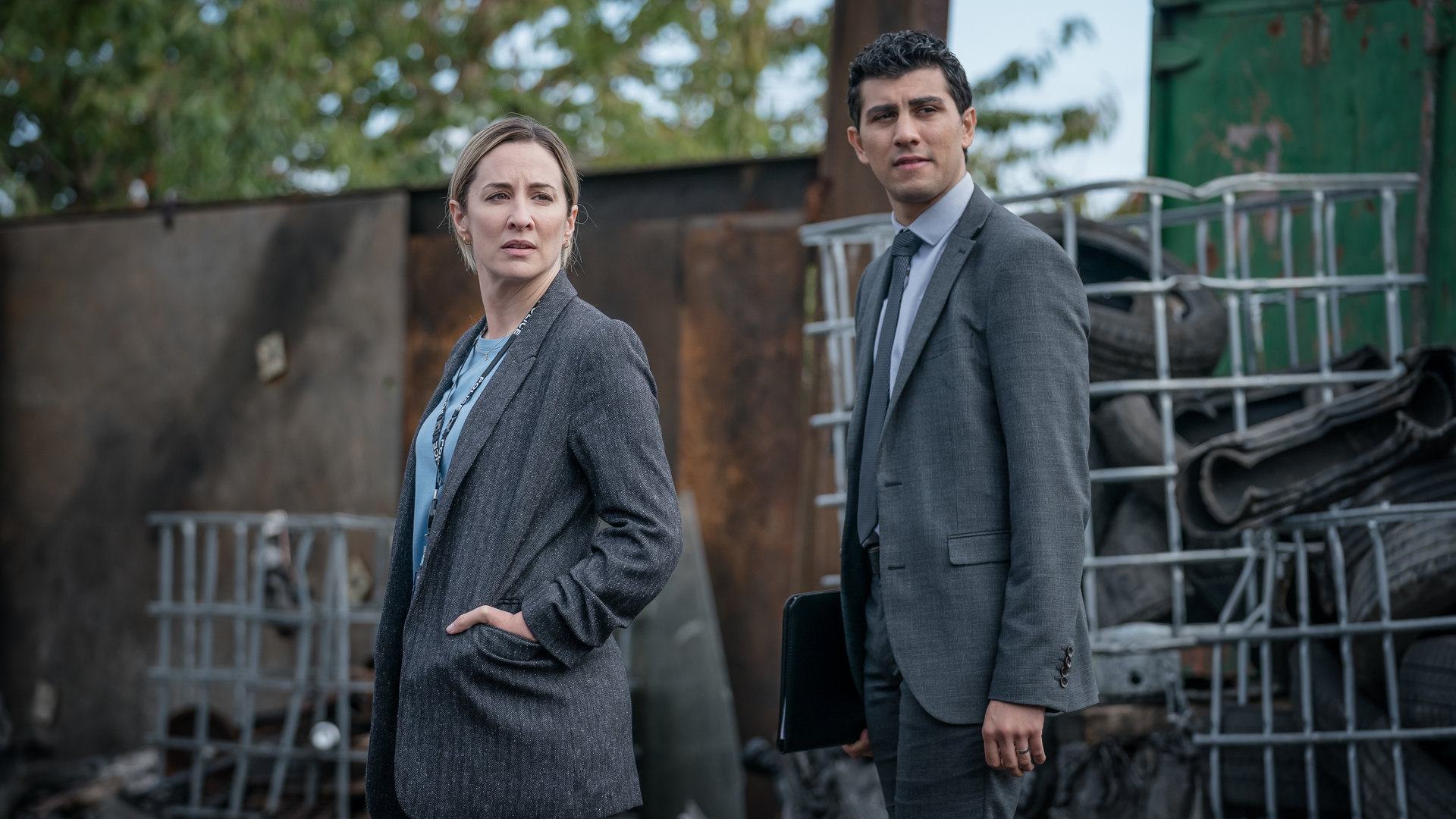 "The Bay - Verbrechen": Lisa Armstrong (Morven Christie) und Ahmed Kharim (Taheen Modak) stehen nebeneinander auf einem Schrottplatz und blicken ernst in die Ferne.