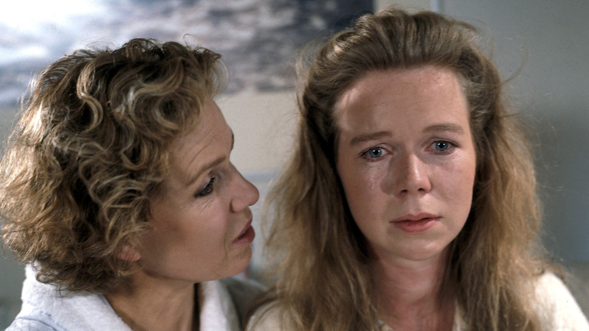 "Diese Drombuschs - Um keinen Preis": Vera (Witta Pohl) und Tina (Marion Kracht) sitzen nebeneinander im Bademantel auf dem Bett. Tina hat Tränen in den Augen.