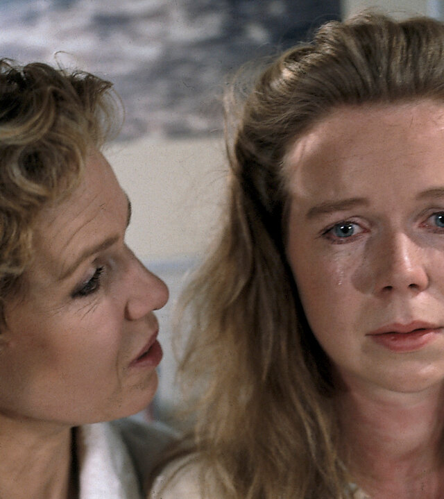 "Diese Drombuschs - Um keinen Preis": Vera (Witta Pohl) und Tina (Marion Kracht) sitzen nebeneinander im Bademantel auf dem Bett. Tina hat Tränen in den Augen.