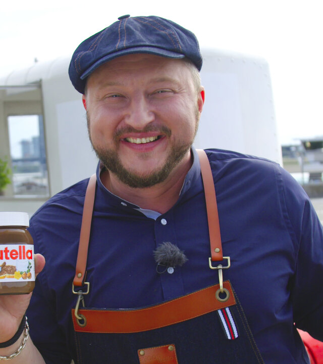 "ZDFzeit - Die Tricks von Ferrero": Sebastian Lege hält lachend ein Glas nutella in die Kamera.