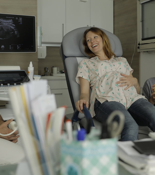 “Andere Eltern - Episode 5“: Im Behandlungszimmer lächeln Nina (Lavinia Wilson) und Jannos (Jasin Challah) den Gynäkologen erleichtert an.