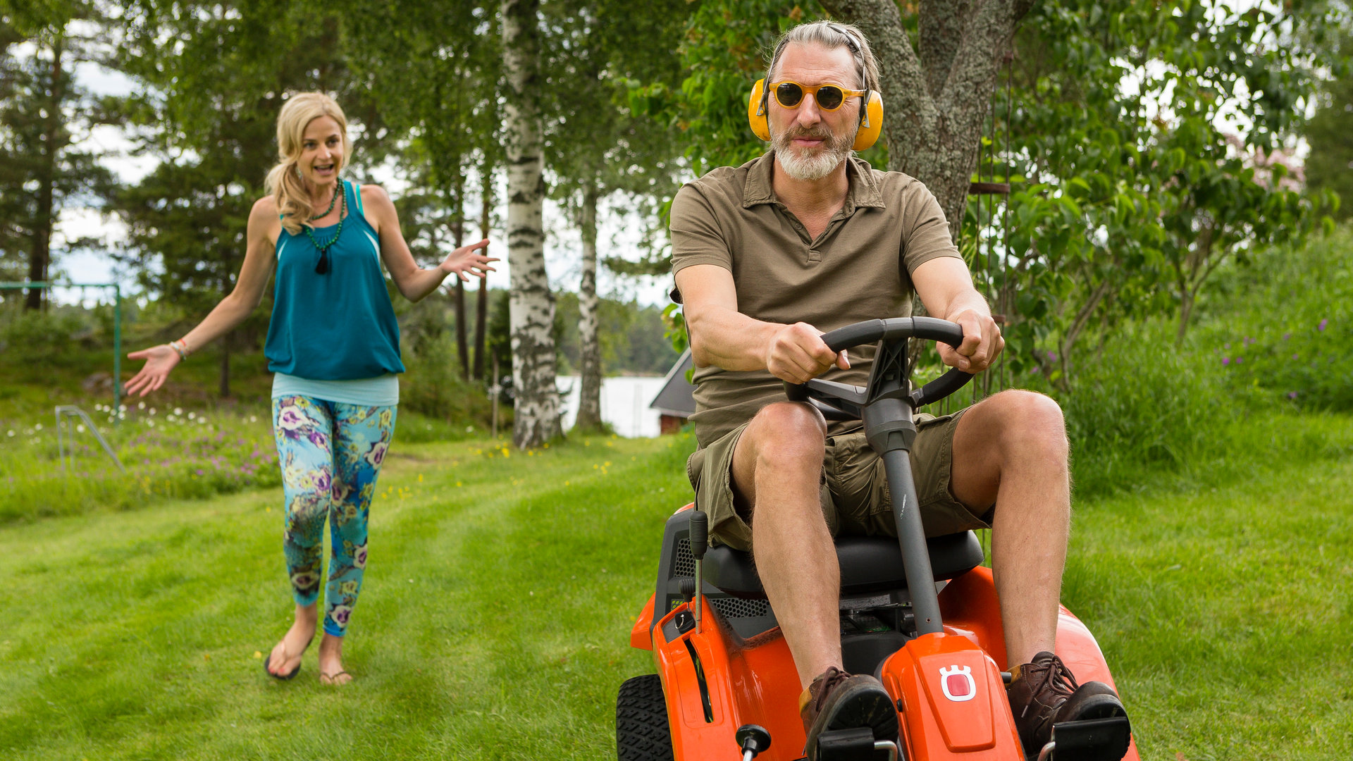 "Inga Lindström: Liebe deinen Nächsten": Esther Carlson (Franziska Schlattner) läuft hinter Marvin Blom (Rufus Beck) her, der gerade seinen Rasen mäht.