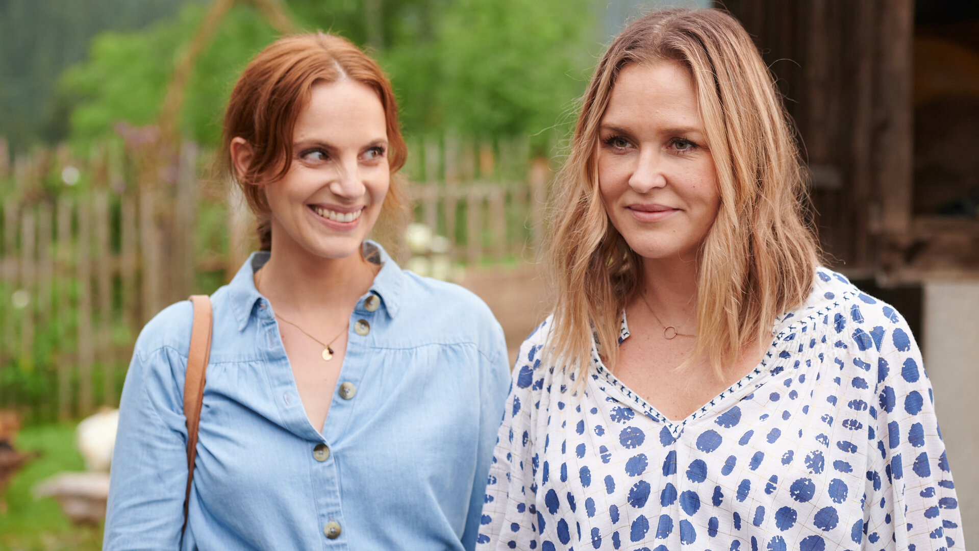 "Lena Lorenz - Zerbrechliches Glück (2)": Bettine Zunhammer (Marie Zielcke) steht neben Lena Lorenz (Judith Hoersch) im Freien und schaut diese strahlend an.