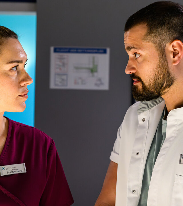 "Bettys Diagnose - Doc Batman": Betty (Henrike Hahn) und Dr. Tarik Sahin (Nicolas Fethi Türksever) stehen nebeneinander im Behandlungszimmer und schauen sich an.