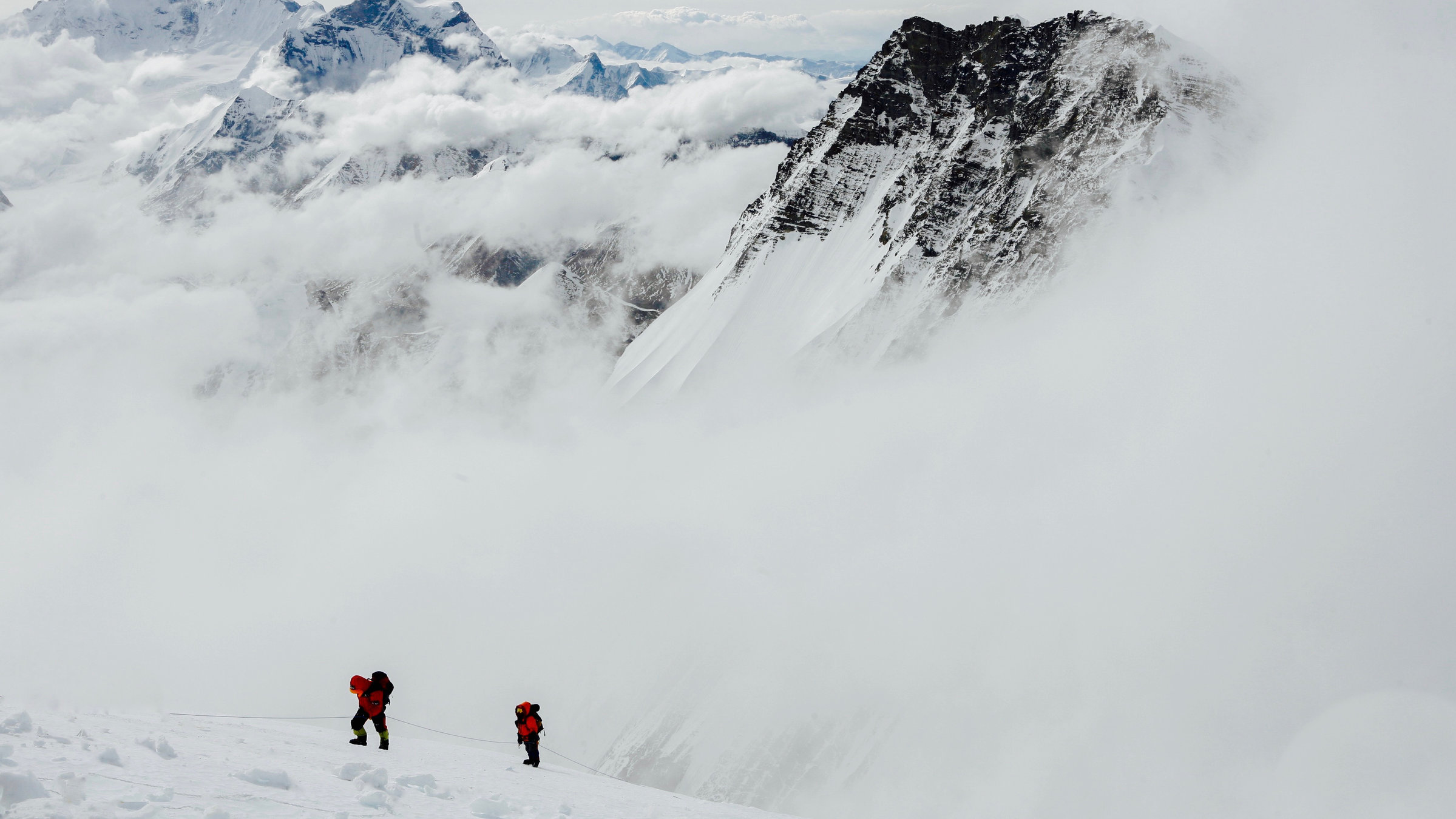 "Mountain": Supertotale von zwei Bergsteigern, die auf einem Schneekamm unterwegs sind. Im Hintergrund ein riesiges Bergmassiv.