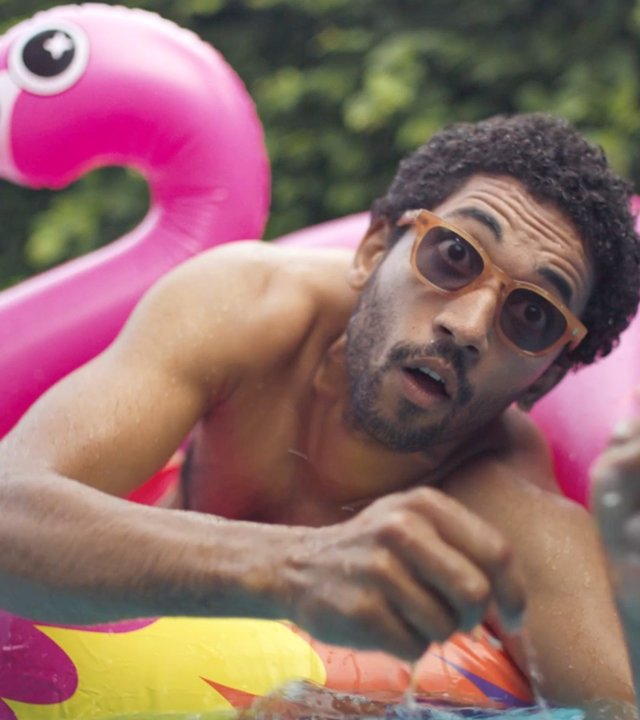 "Doppelhaushälfte - Schall und Rauch": Theo (Benito Bause) sitzt in einem pinkfarbenen aufblasbaren Riesenflamingo im Pool und blickt erschrocken.