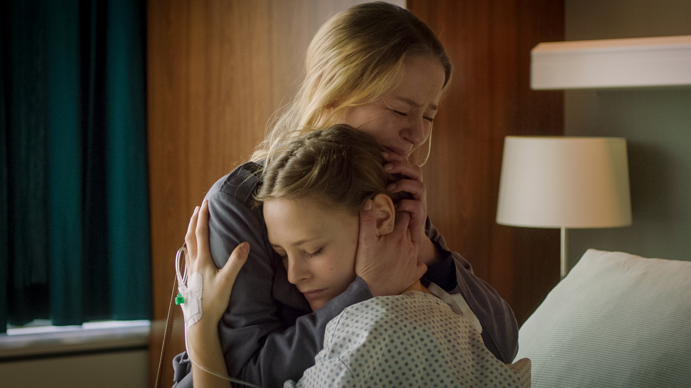 "Doktor Ballouz - Scherbenhaufen": Sabrina (Theresa Scholze, l.) hält ihre Tochter Lilly (Liselotte Krieger, r.) im Arm, die im Krankenbett sitzt.