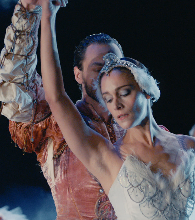 "L' Opéra - Dancing in Paris - Weg zurück": Jonas (Loris Freeman) steht auf einer Bühne dicht hinter Zoé (Ariane Labed) im Scheinwerferlicht. Beide sind kostümiert und tanzen einen Abschnitt aus Schwanensee.