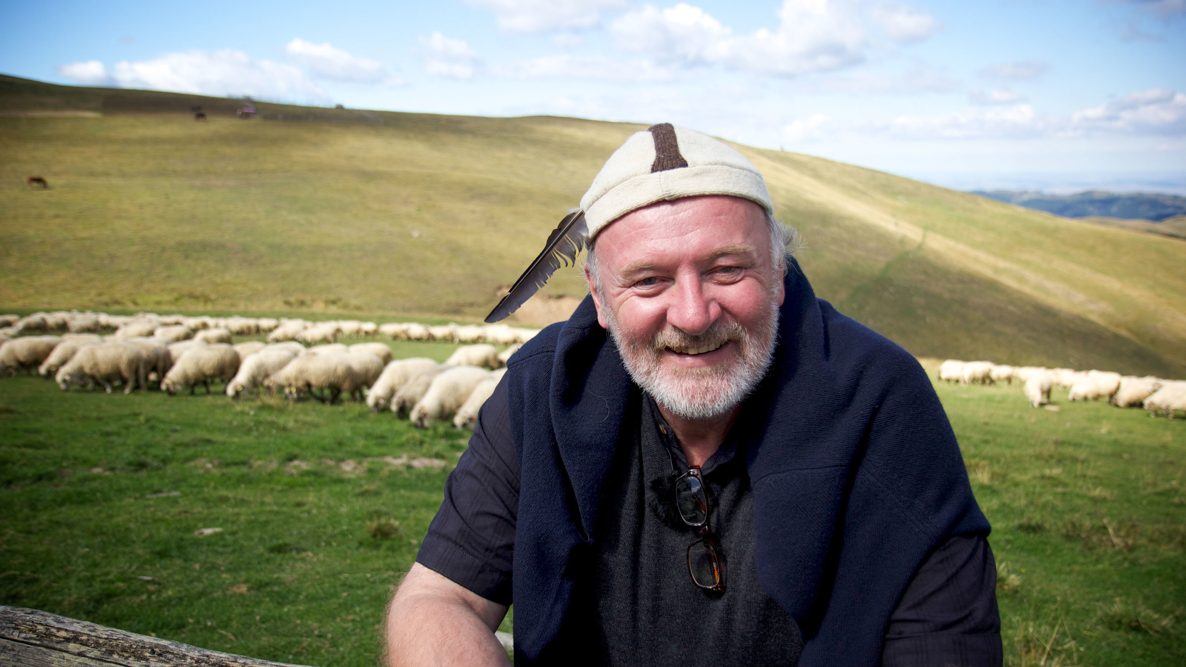 "Der Geschmack Europas - Siebenbürgen": Präsentator Lojze Wieser steht auf einer Wiese , im Hintergrund eine Schafherde.