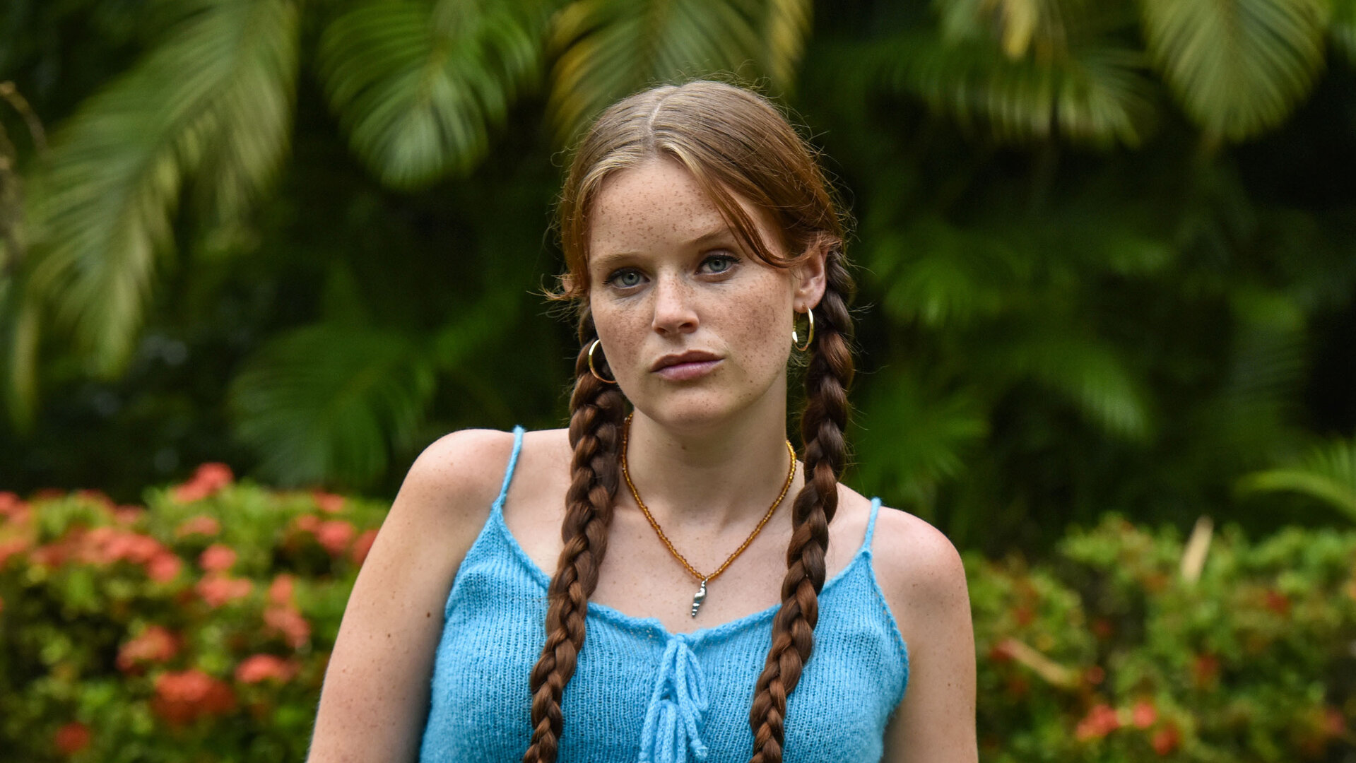 "Death in Paradise - Die Schlange": In einem Garten steht Daisy McCrae (Imogen King). Die Hände hat sie locker in die Hosentaschen gesteckt.