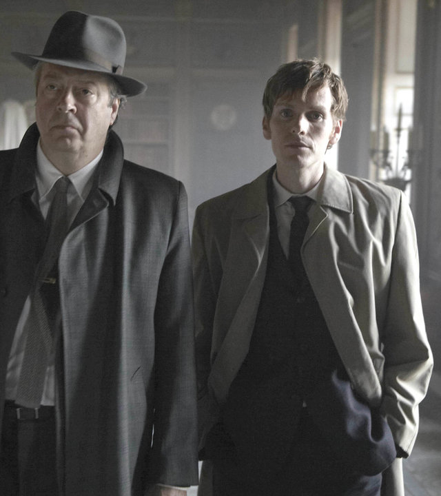 "Der junge Inspektor Morse - Ein Gedicht": Fred Thursday (Roger Allam) und Endeavour Morse (Shaun Evans) laufen nebeneinander einen Flur in einem Schloss entlang.