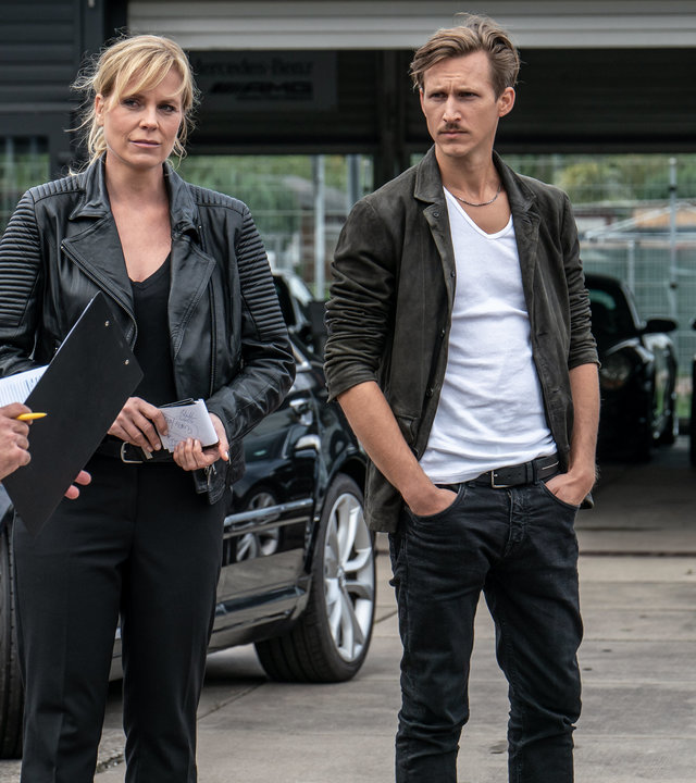 "SOKO Leipzig - Für Luise":  Jan Maybach (Marco Girnth), Ina Zimmermann (Melanie Marschke), Moritz Brenner (Johannes Hendrik Langer) und Kim Nowak (Amy Mußul) stehen vor einem Autohaus nebeneinander und besprechen sich.