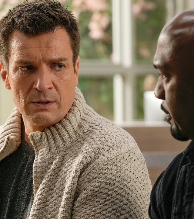 "The Rookie - Gebrochene Herzen": Nolan (Nathan Fillion) sitzt neben Sergeant Grey (Richard T. Jones) in einem Wartezimmer und schaut ihn niedergeschlagen an.